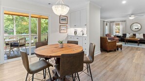 Un vaste espace de vie comprenant une table à manger en bois, des sièges confortables et une vue sur l’extérieur.