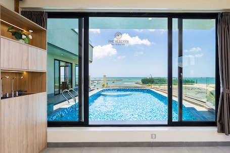 Una piscina al aire libre, sombrillas, sillones reclinables de piscina