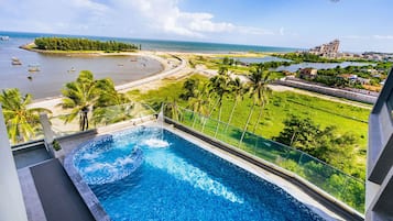 Alberca al aire libre, sombrillas en la alberca y camastros