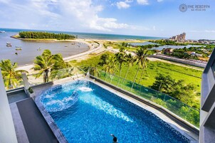 Una piscina al aire libre, sombrillas, sillones reclinables de piscina