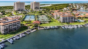 A coastal resort with multiple high-rise buildings, a marina, and a tennis court.