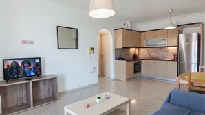 A modern living room with a TV, a sofa, and a coffee table. - Modern Equipped apt w Balcony GC 3120-02 (Athens)