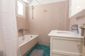 A bathroom with a bathtub, a sink, and a shower. - Comfy New Apt w Balcony GC 3360-01 (Athens)