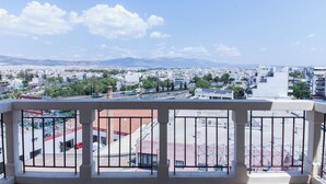A balcony with a view of a cityscape, including buildings and mountains in the distance. - Gorgeous Apt w Magical View GC 3332-02 (Athens)