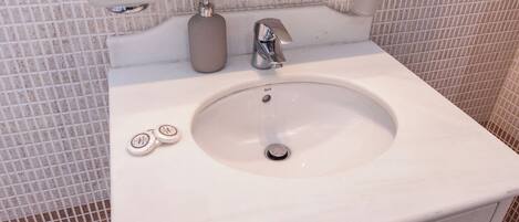 A bathroom sink with a mirror above it, a faucet, and two soap dispensers.