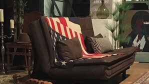 A living room with a sofa, a patterned rug, and a large cowhide rug. - Unique yoga loft! Quiet room for courses, seminars, workshops! (Sinsheim)