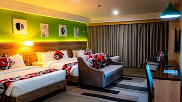 A hotel room with two beds, a sofa, a desk, and a TV.