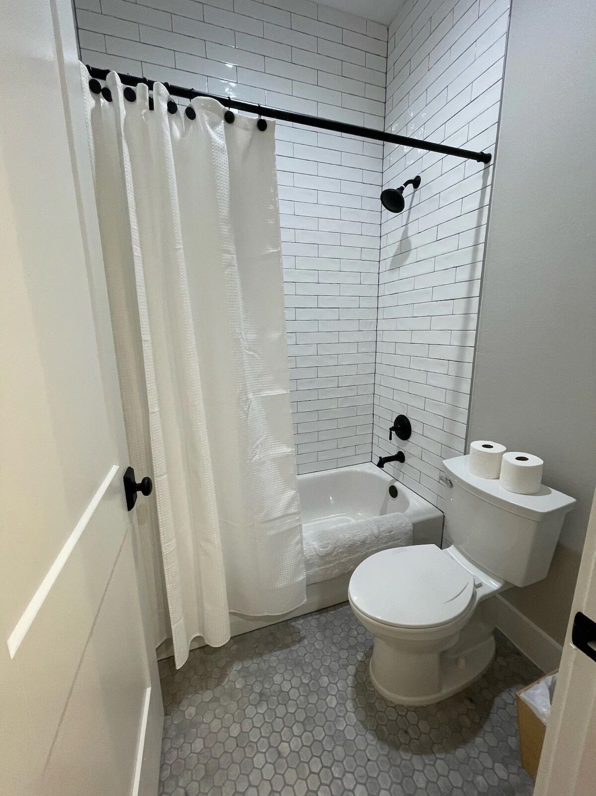 Un baño con una bañera blanca, inodoro y cortina de ducha.