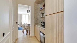 Una cocina moderna con muebles de madera, un horno empotrado y un comedor con alfombra azul.