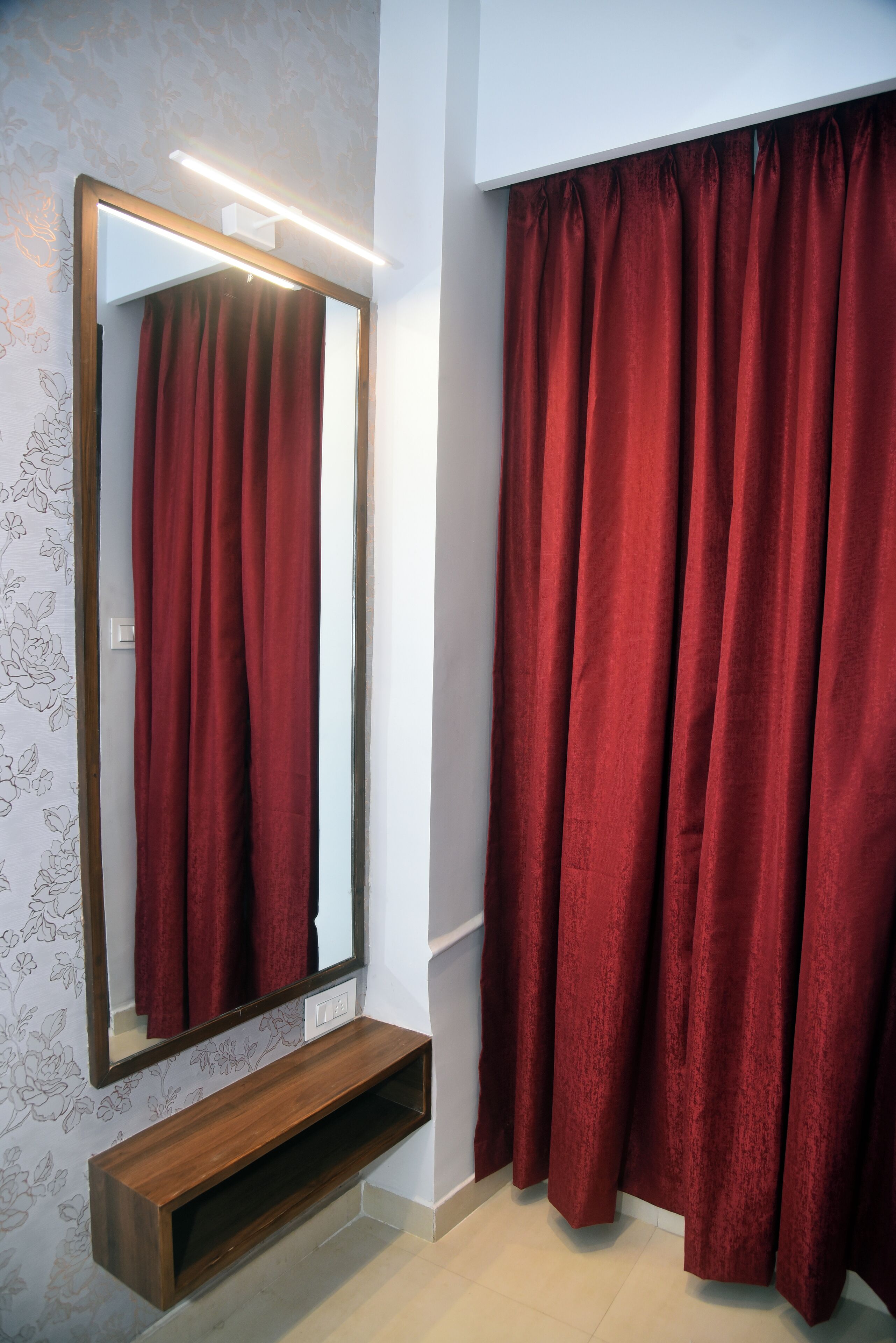 Ein Badezimmer mit einem großen Spiegel, roten Vorhängen und einer Holzkammer.