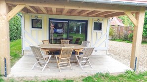 Relax on the patio surrounded by a grassy lawn and enjoy meals at the wooden table.