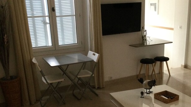 Ein Wohnzimmer mit Esstisch, Stühlen, einer Couch und einem Couchtisch.