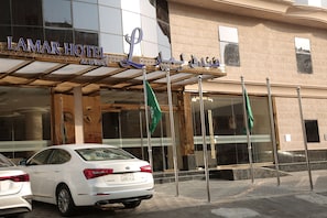The exterior of the Lamar Hotel with a modern facade, large glass windows, and a prominent entrance with flags. - Lamar Al Bawadi Hotel (Jeddah)