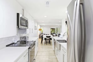 A modern kitchen with a microwave, oven, and refrigerator.