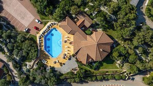 An aerial view of a property with a swimming pool, multiple buildings, and surrounding greenery. - Chic Villa Antonina Studio No2167 (Golfo Aranci)