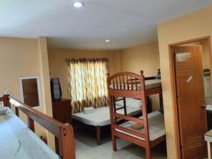 A room with bunk beds, a desk, a chair, a mirror, and a door. - Allen Marie Shiphaus powered by Cocotel (Santa Fe)