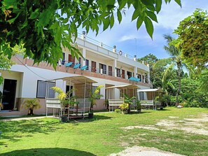 A two-story building with a flat roof, multiple balconies, and a covered outdoor seating area. - Allen Marie Shiphaus powered by Cocotel (Santa Fe)
