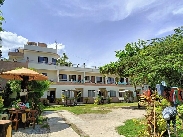 A multi-story building with outdoor seating and a covered area. - Allen Marie Shiphaus powered by Cocotel (Santa Fe)