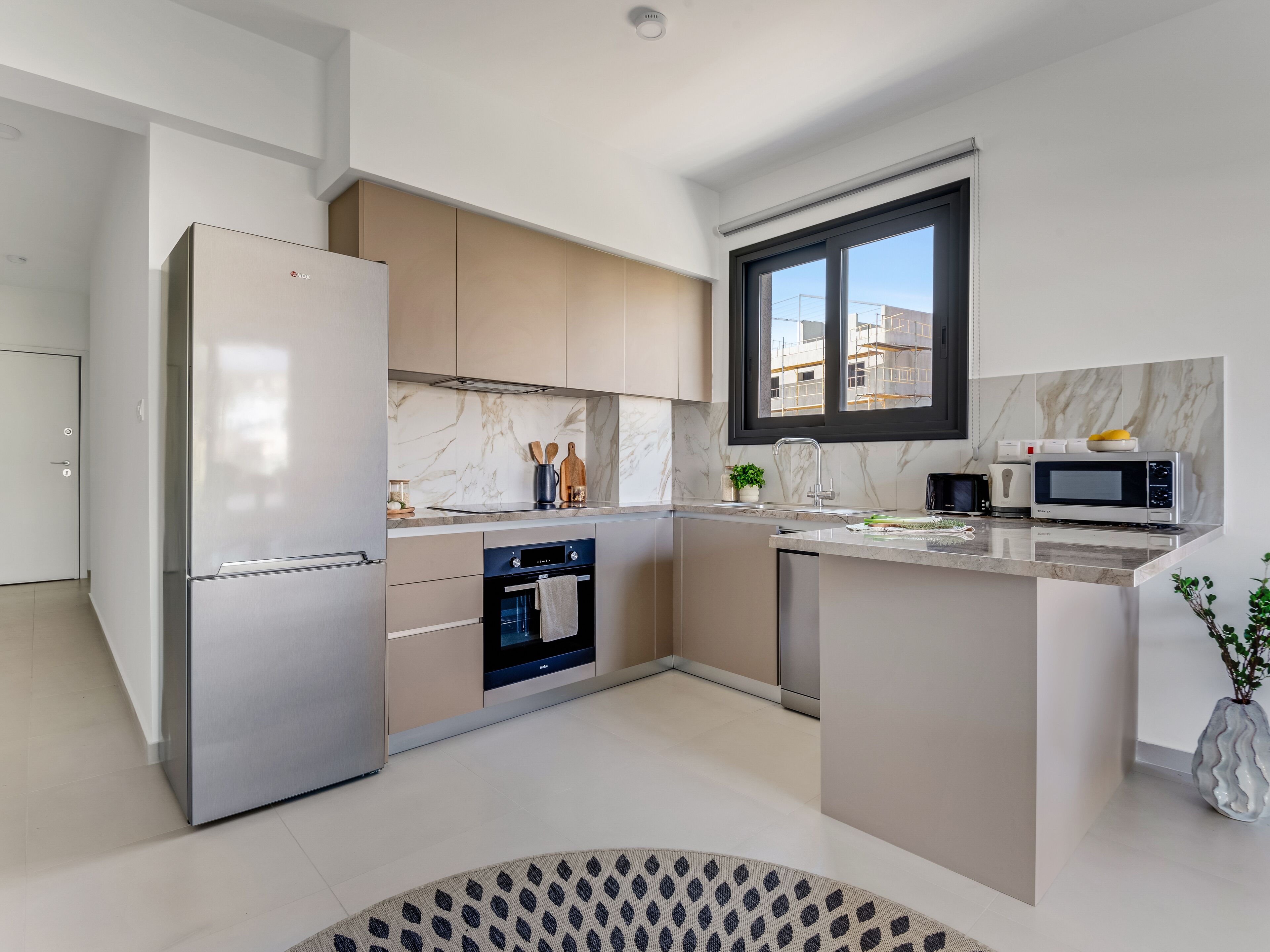 A modern kitchen with a built-in oven, microwave, and refrigerator.
