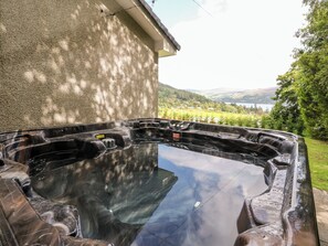 A hot tub with a clear view of a lake and hills in the background. - Beech Cottage (Aberfeldy)