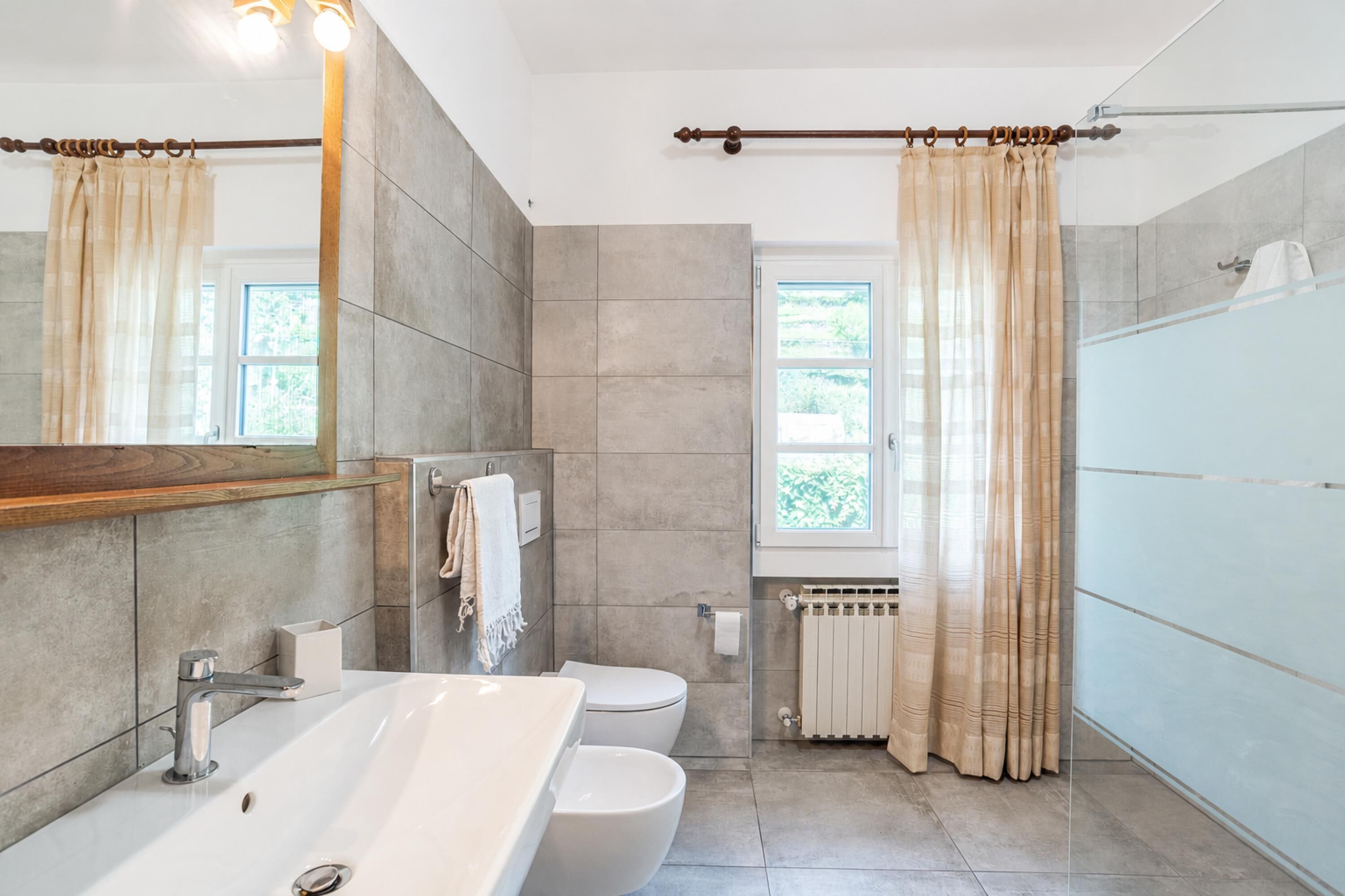 A modern bathroom with a large bathtub, a toilet, and a shower area.