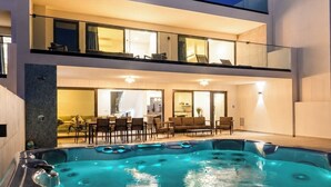 Una casa moderna de dos pisos con jacuzzi en el jardín trasero.