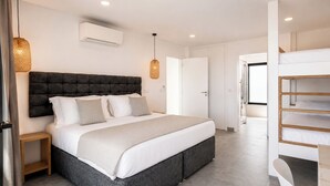 Un dormitorio moderno con una cama grande, mesitas de noche, un banco empotrado y vistas al pasillo.