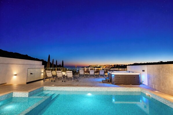 Piscina no terraço com vista para a cidade ao entardecer.
