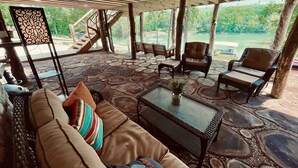 An outdoor patio with stone flooring, wicker furniture, and a view of a lake. - “Triple Timbers” 18 bdrm,sleeps 56! hotubs, docks, 5 firepits, sxs, rent boats (Lafollette)