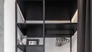 Un armario metálico negro con estantes y un refrigerador pequeño.