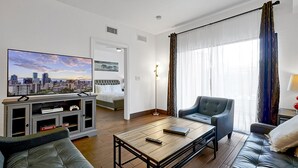 A modern living room with a flat-screen TV, a sofa, a coffee table, and a chair. - Floridays Resort Retreat | Relax & Explore Orlando (orlando)