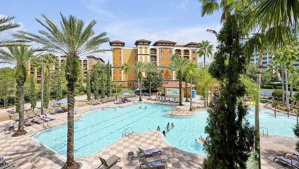 A hotel with a large swimming pool surrounded by palm trees and lounge chairs. - Floridays Resort Retreat | Relax & Explore Orlando (orlando)