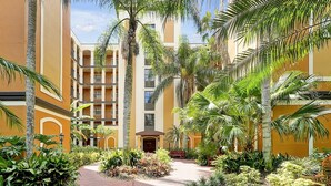 A courtyard with a central pathway, surrounded by palm trees and various plants. - Floridays Resort Retreat | Relax & Explore Orlando (orlando)