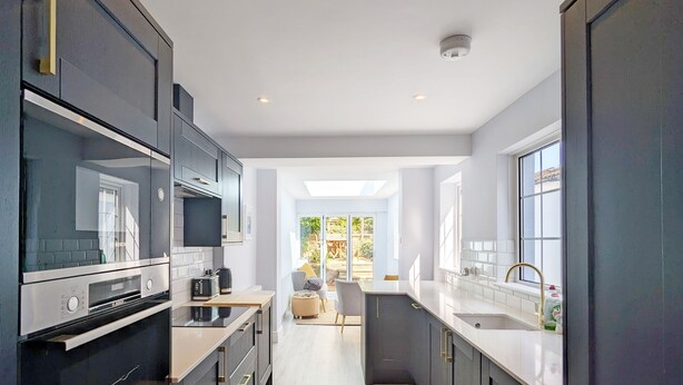A modern kitchen with dark cabinetry, stainless steel appliances, and a central island. - Grace Cottage - Emsworth -  a cottage that sleeps 6 guests  in 3 bedrooms (Emsworth)