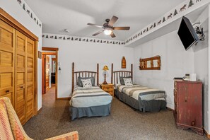 A bedroom with two beds, a ceiling fan, a TV mounted on the wall, and a wooden wardrobe. - Luxury Mountain Escape| The Terraces at EagleRidge! (Steamboat Springs)
