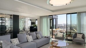 Un salon moderne avec un canapé gris, une table basse et un coin repas comprenant une table et des chaises.