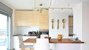 Une cuisine moderne avec des meubles en bois, un îlot central doté d’un plan de travail en bois et un luminaire suspendu.