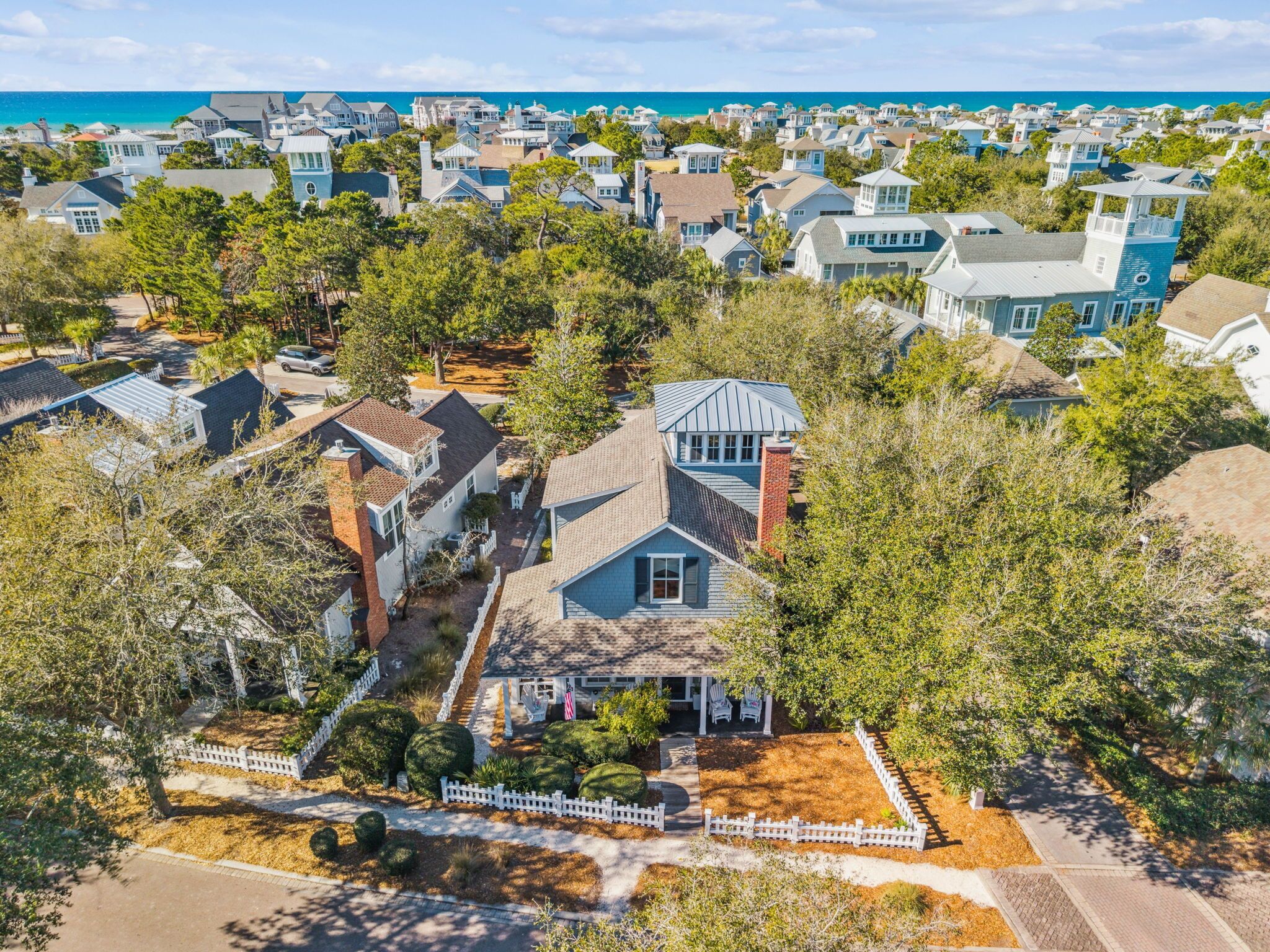 Zona residencial con casas, árboles y vista al océano.
