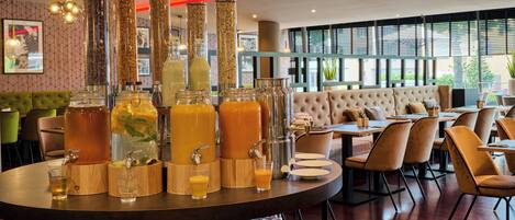 Un restaurant doté d’un bar, de tables rondes et d’un espace salon avec des fauteuils confortables.