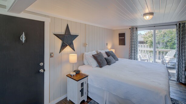 Une chambre à coucher avec un lit, une décoration en forme d’étoile, une table de chevet et une fenêtre avec des rideaux.