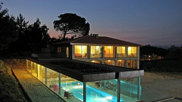 Ein modernes, zweistöckiges Haus mit einem überdachten Schwimmbad.