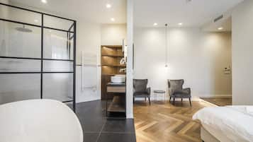 A modern bathroom with a freestanding bathtub, a glass shower enclosure, and a wooden vanity.