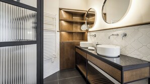 Een moderne badkamer met twee wastafels, een spiegel en een houten wastafelmeubel.
