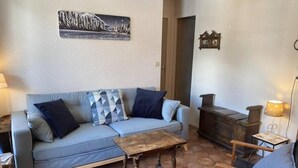 A cozy living room with a sofa, a wooden coffee table, and a chair. - 350m from ski slopes, 3rd floor, balcony, parking, tv, ski locker, 39m², Valloire (Valloire)