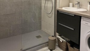 A modern bathroom with a glass-enclosed shower, a sink with a mirror above, and a washing machine. - 350m from ski slopes, 3rd floor, balcony, parking, tv, ski locker, 39m², Valloire (Valloire)