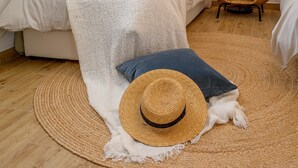 A room with a large woven rug, a white sofa, a blue pillow, and a straw hat. - Luxury Villa Essencia Milna Brac with Heated Pool (Milna (Brac))