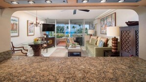 A kitchen with granite countertops, wooden cabinets, and a dining area with a table and chairs.