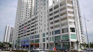 A multi-story building with a modern architectural design, featuring a ground-level commercial space with a sushi restaurant.