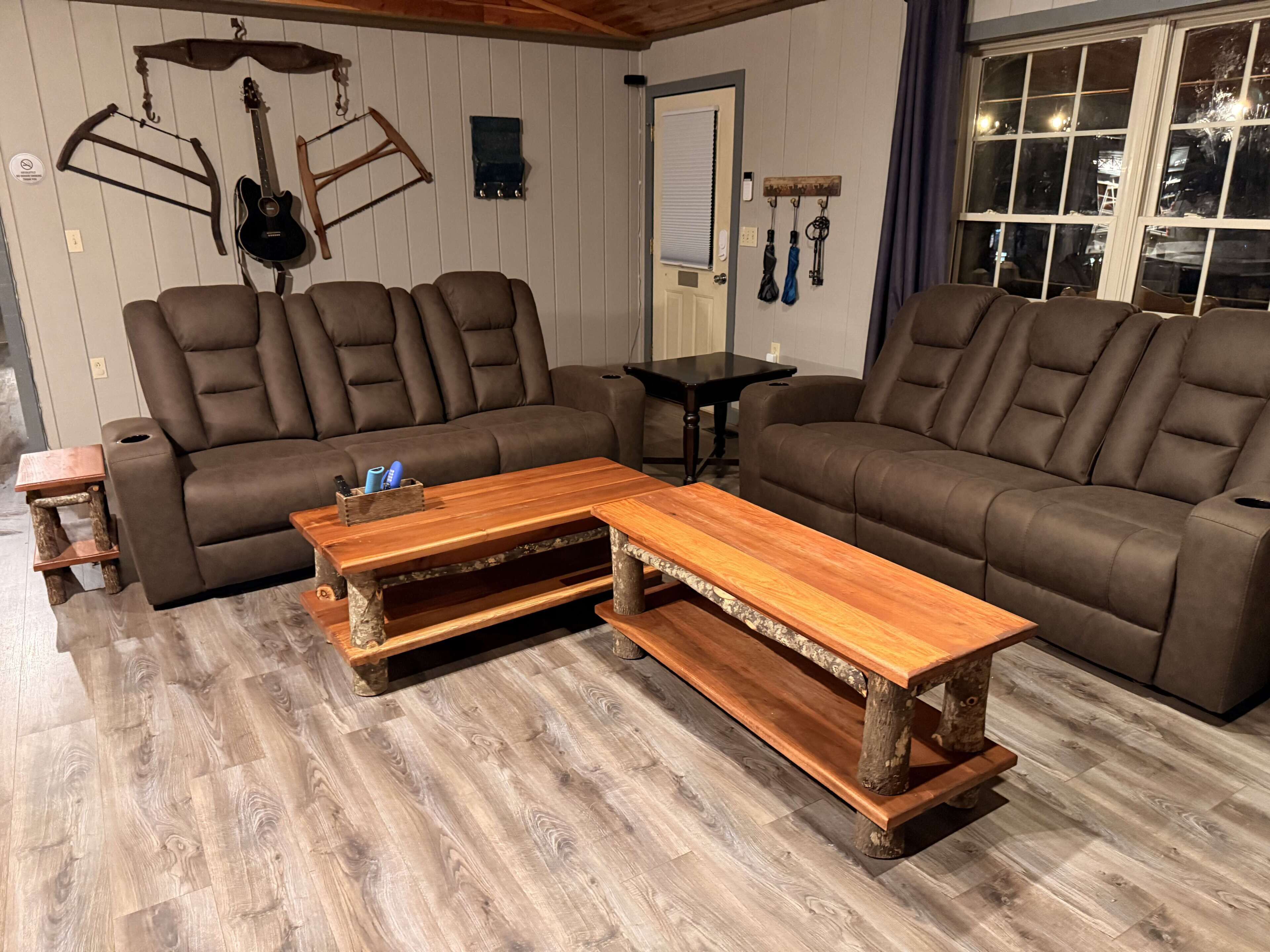 A living room with a brown leather sectional sofa, a wooden coffee table, and a wooden floor.