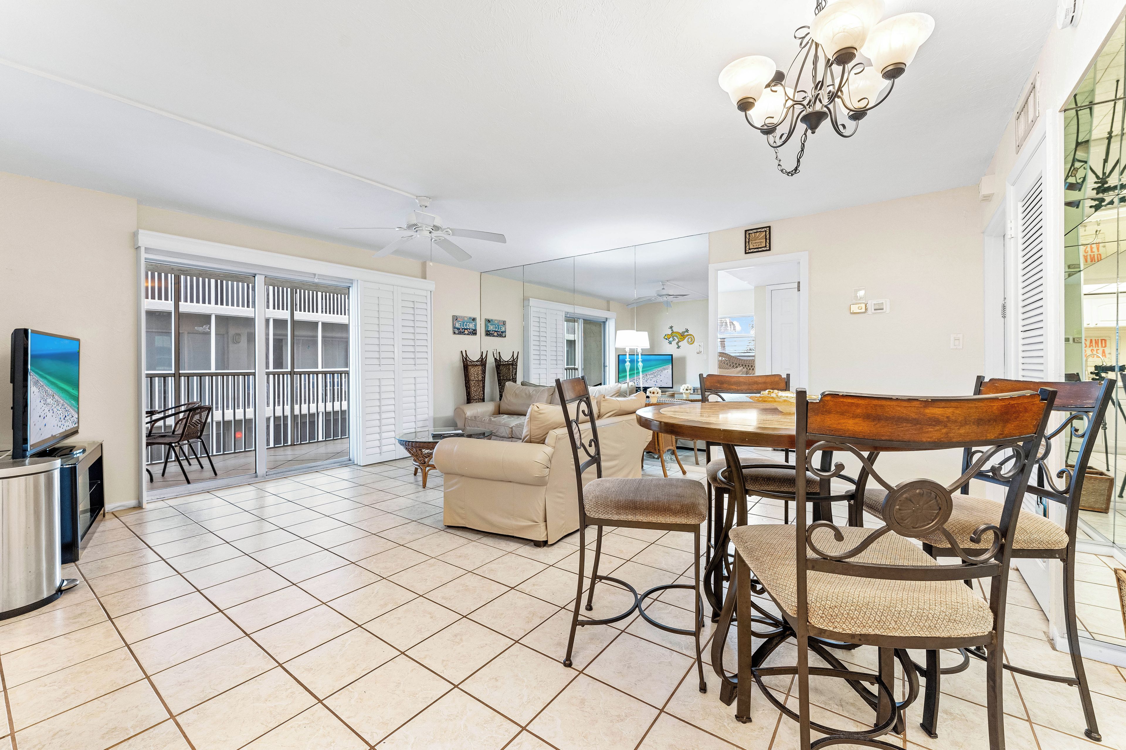 A spacious living area with a dining table, chairs, a sofa, and a TV.